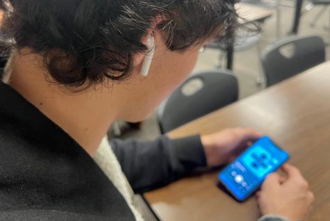 Student Jack Ward listening to music with his Airpods. 