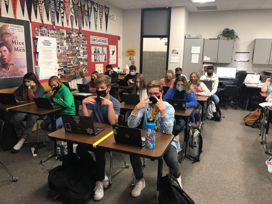 Clad in masks, students pose for a photo in their English class.