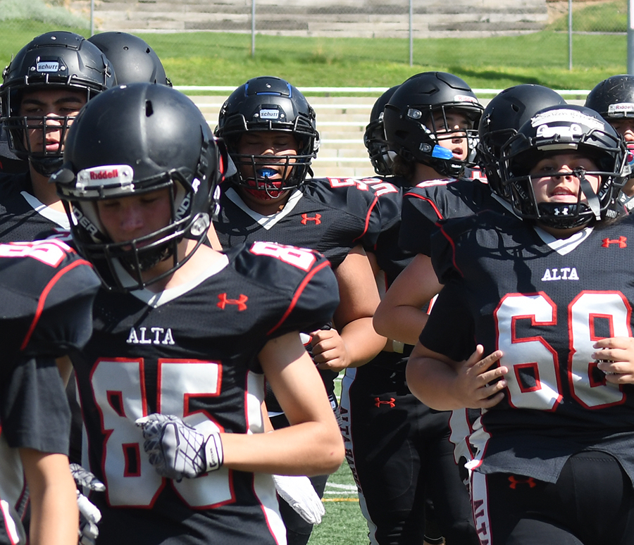 Saleen Reynolds, number 68, (far right) runs onto the field with her teammates on the Freshmen - Sophomore Alta football team.