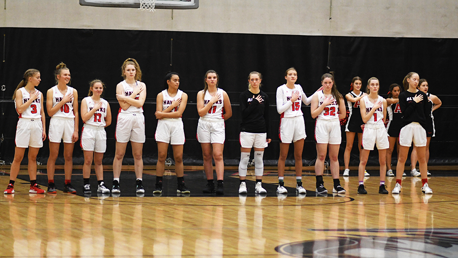 Last year's Girl's Basketball Team pauses before a game for the National Anthem. This year's team is ready to hit the court running and have a successful season.