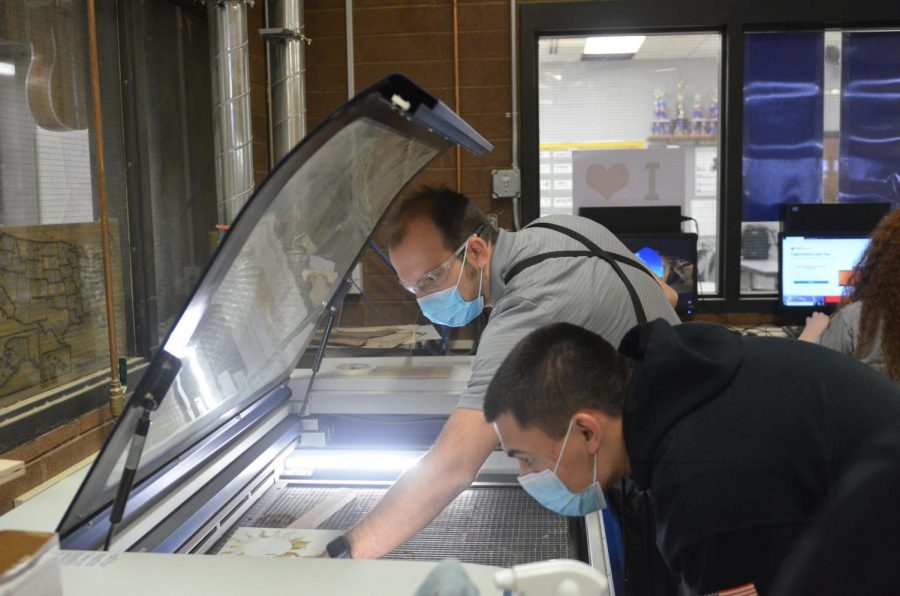 In addition to their daily teaching jobs, many teachers turn to outside employment to make ends meet.
Above, Woods teacher Joey Newman works with Josh Lloyd on the laser printer during class.