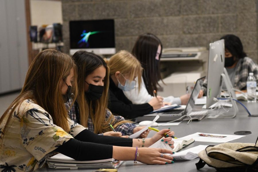 Students wear masks to study in school library.