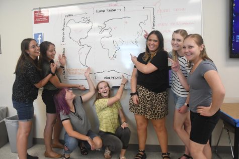 Step2theU 2019 participants pose in front of a visual aide for a group project at the Sandy City University of Utah Campus.