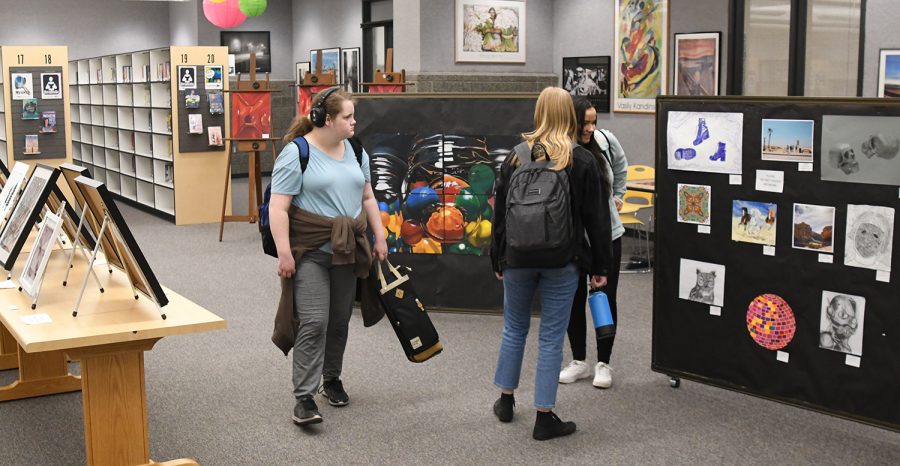 Students take some time to explore this years student art show in the Media Center. All five art teachers have collected art, photography, ceramics, and jewelry to represent the best student art from this year.