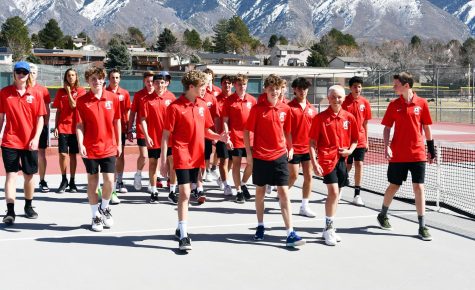 The boys tennis team walks off the courts following a group photo.