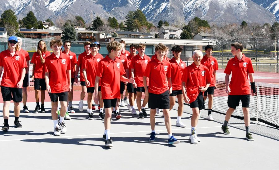 The boy's tennis team walks off the courts following a group photo.