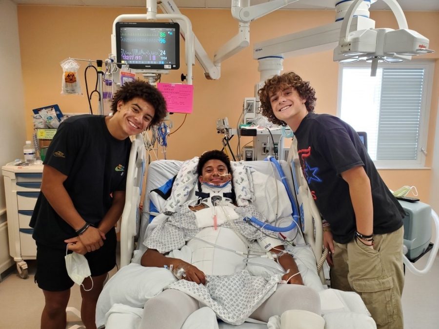 Football team captain Noah Flores, Jalen Sutton, and Drew Monson pose for a photo in Jalen's hospital room . Sutton continues to recover from his football injuries earlier this season.