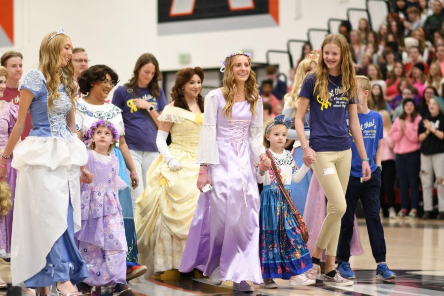 Students dress as Disney Princesses and parade in front of the student body as part of this year's Make-a-Wish assembly. The students hope to raise enough money to send Elle and her family to Disneyworld.