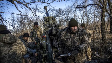Ukranian soldiers load an artillery cannon outside Bakhmut.